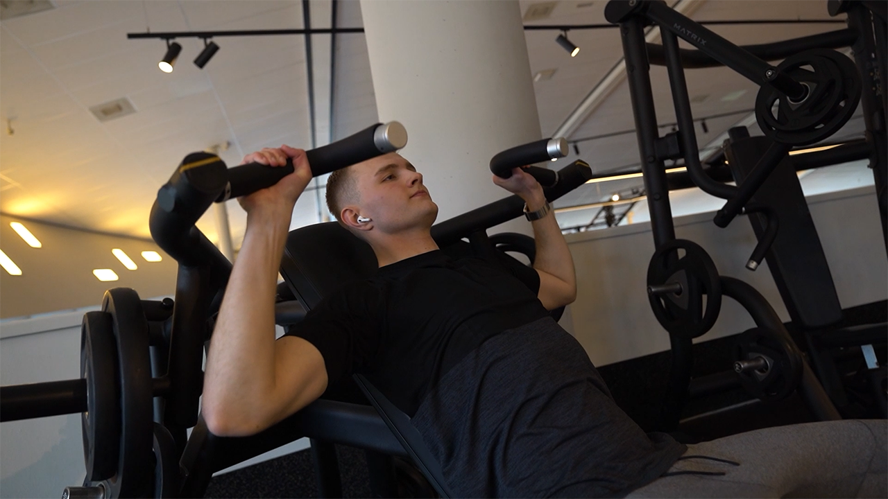 Performing an incline chest press machine exercise for greater upper ...