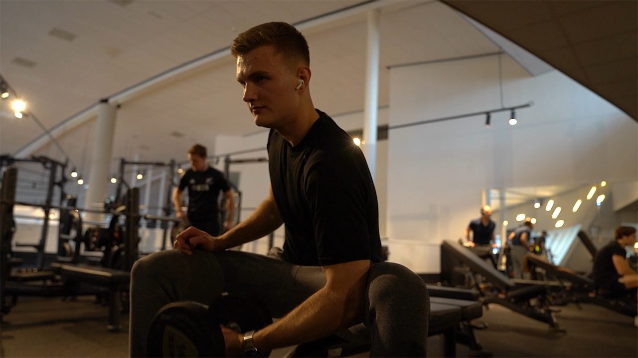 Performing a single arm dumbbell curl to build stronger biceps