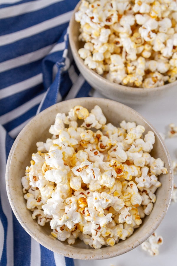 looking down into two bowls of popcorn with a blue cloth to the left.
