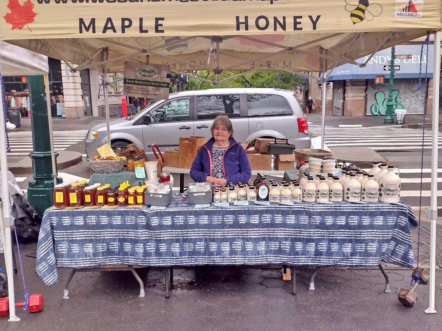Alison's grandma stands in a tent at a farmers market.