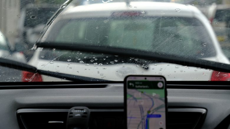 A driver using Google Maps on a rainy day