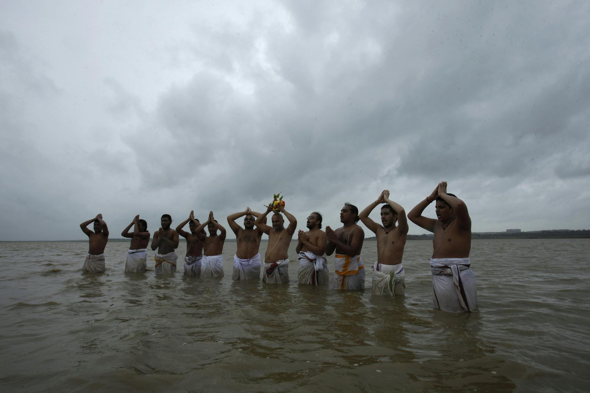 Priests offer prayers to Varuna, the Hindu god of rain, as they stand in the Osman Sagar on the outskirts of Hyderabad, India, on July 16, 2013.