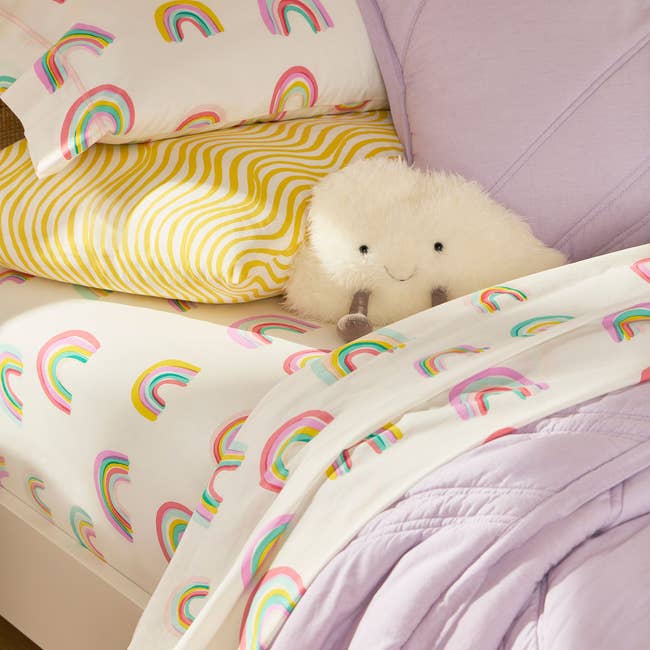 Bed with rainbow-patterned sheets