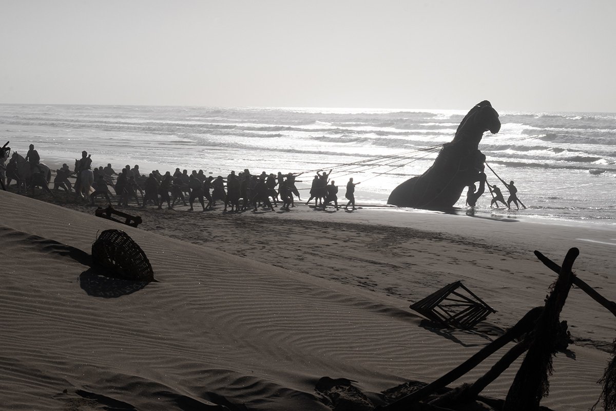 The Greeks pull the Trojan Horse up the beach in The Odyssey
