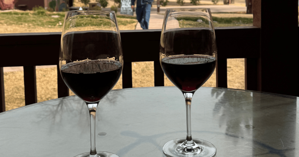 two wine glasses on a table on the porch at da ranch in cornville arizona