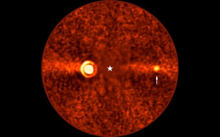 a circle filled with orange, red and black static denoting a debris disk; a star shape at the center, and two exoplanets, one fainter than the other