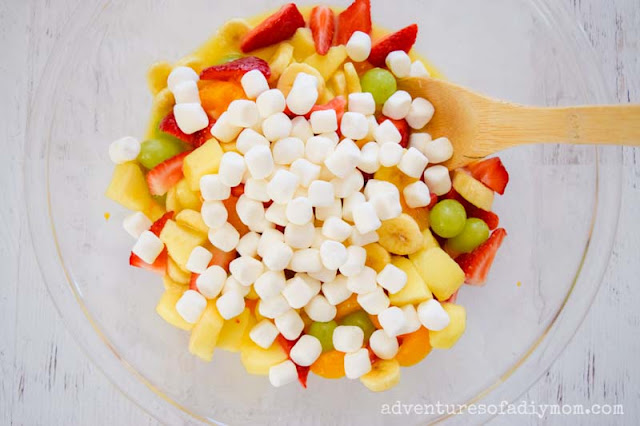 adding marshmallows to simple fruit salad