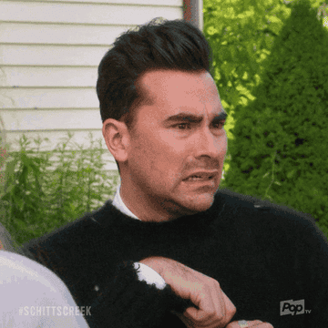 Dan Levy grimmacing in