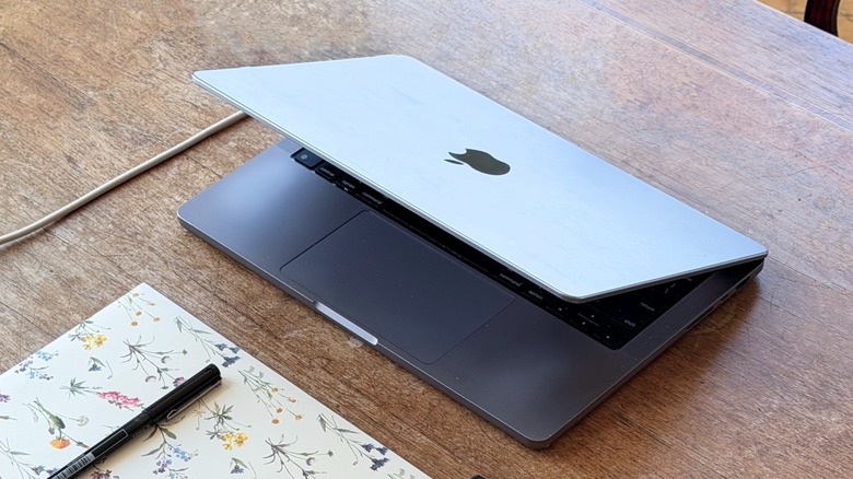 Half-opened MacBook Pro on a wooden table