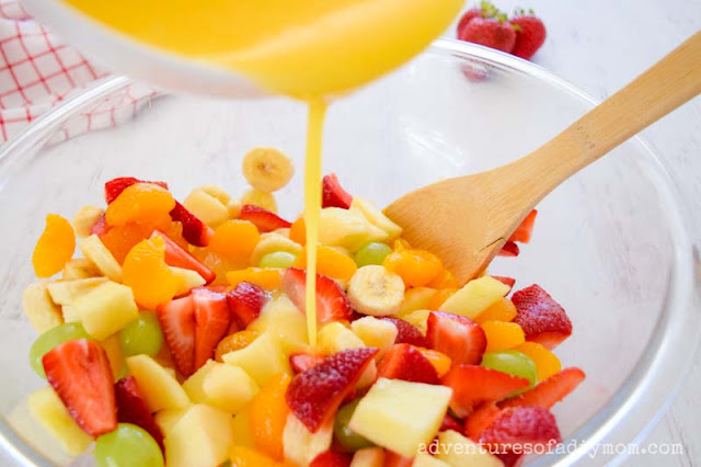 adding sauce mix to fruit salad