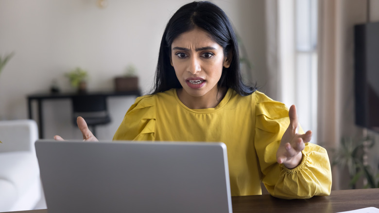 Frustrated laptop user reacting to an unexpected computer problem.