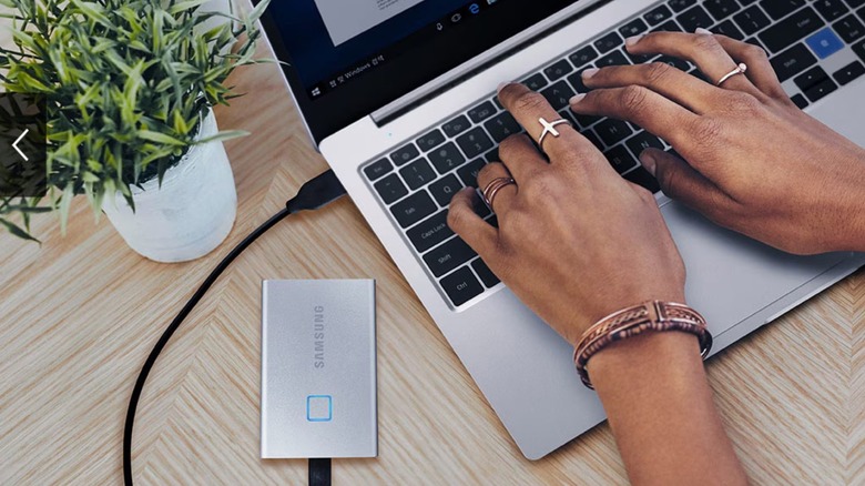 A woman working on a laptop with Samsung's portable SSD connected via USB-C