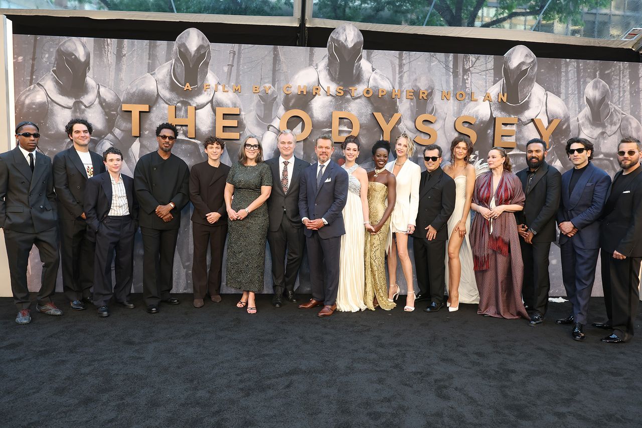 A group of actors and contributors posing on a red carpet event