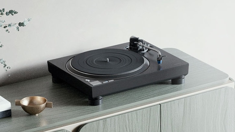 A black Technics SL-100C Hi-Fi Record Player sits on a counter next to a small bronze bowl