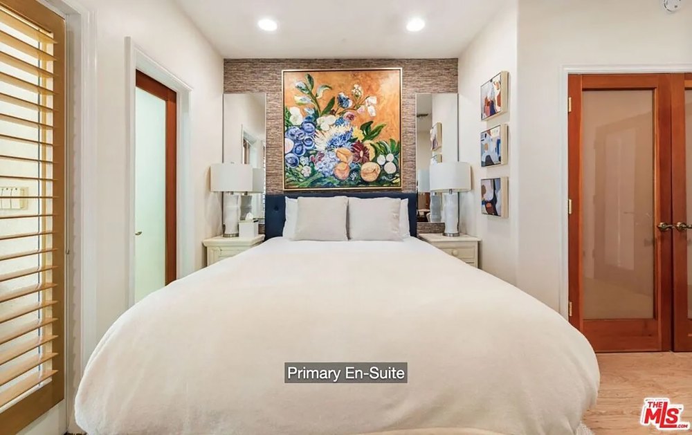 Elegant primary bedroom suite with an eye-catching floral headboard art piece.