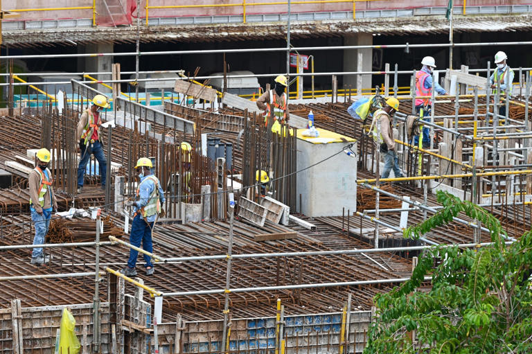 Migrant workers on a construction site in Singapore. The city's growth model historically combined labour force expansion with productivity improvements. Photo: AFP