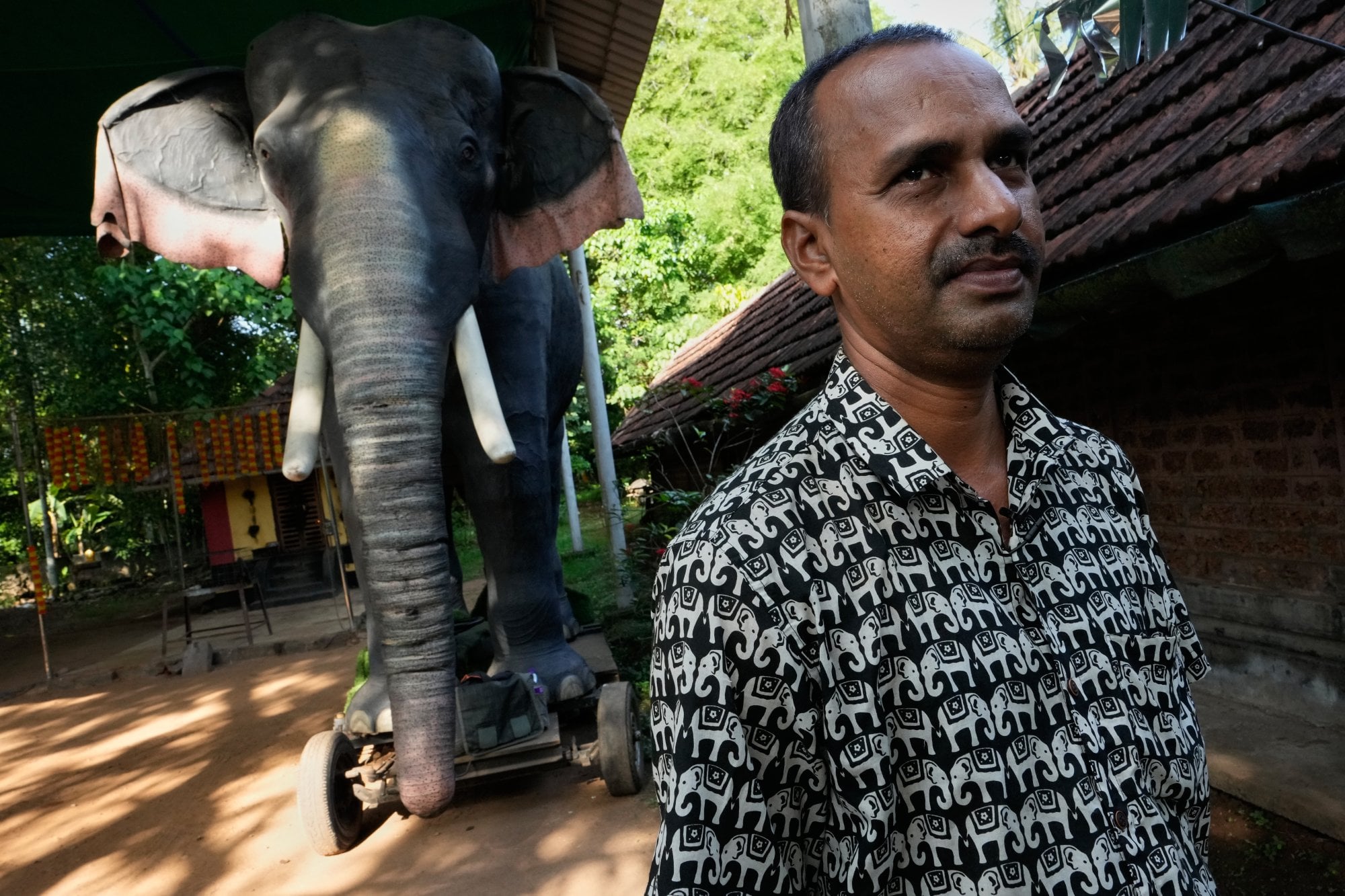 Rajkumar Namboothiri, the temple's head priest, stands next to the robotic elephant Irinjadapilly Raman at the Irinjadapilly Sree Krishna Temple in Thrissur, in Kerala, India, in May. Photo: AP