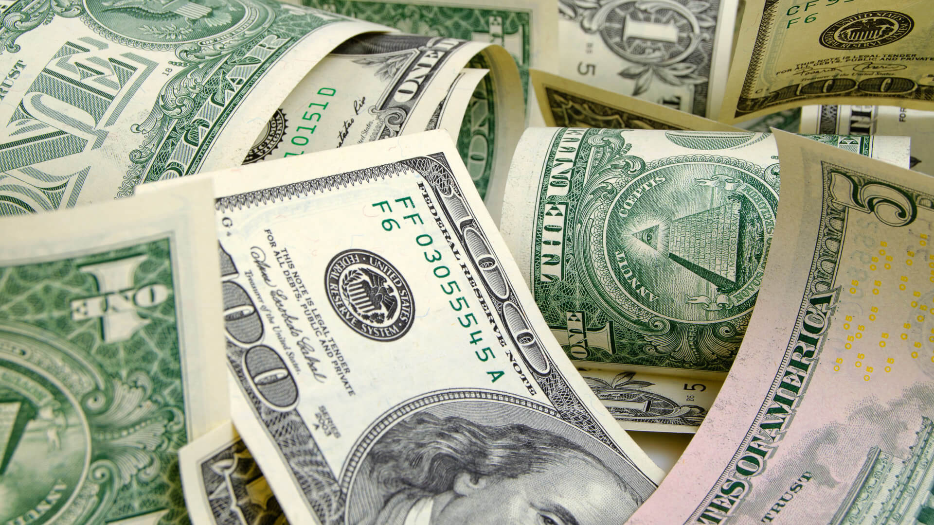Discover a stack of mixed cash bills arranged together, featuring various denominations without highlighting any specific one