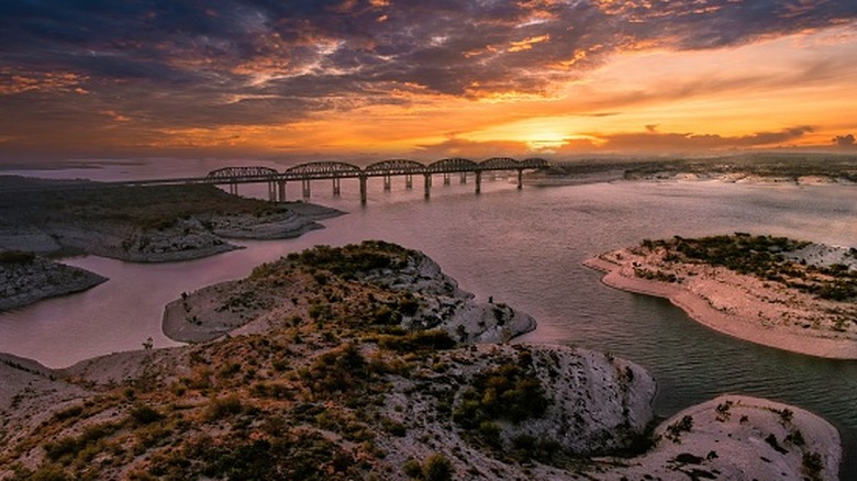 An aerial view of Lake Amistad and the Governor's Landing Bridge at sunset