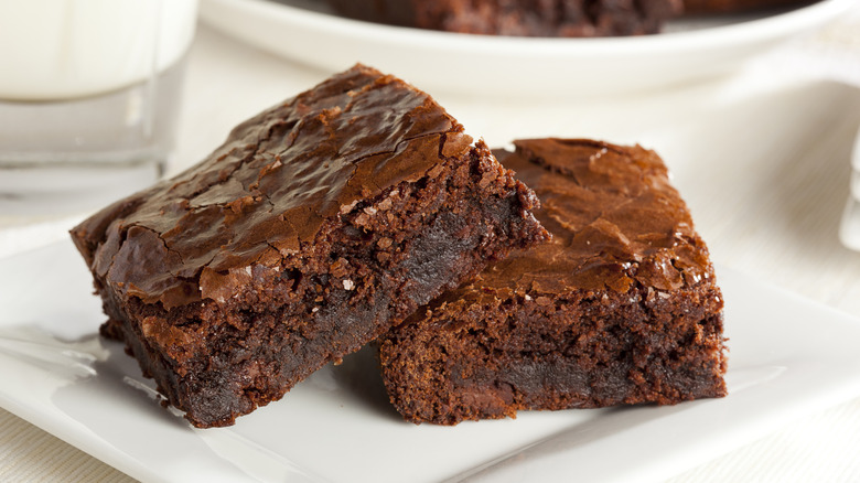 Two fudgy brownies on a white plate