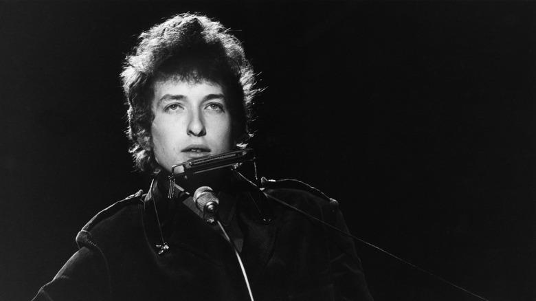 Bob Dylan onstage with guitar and harmonica