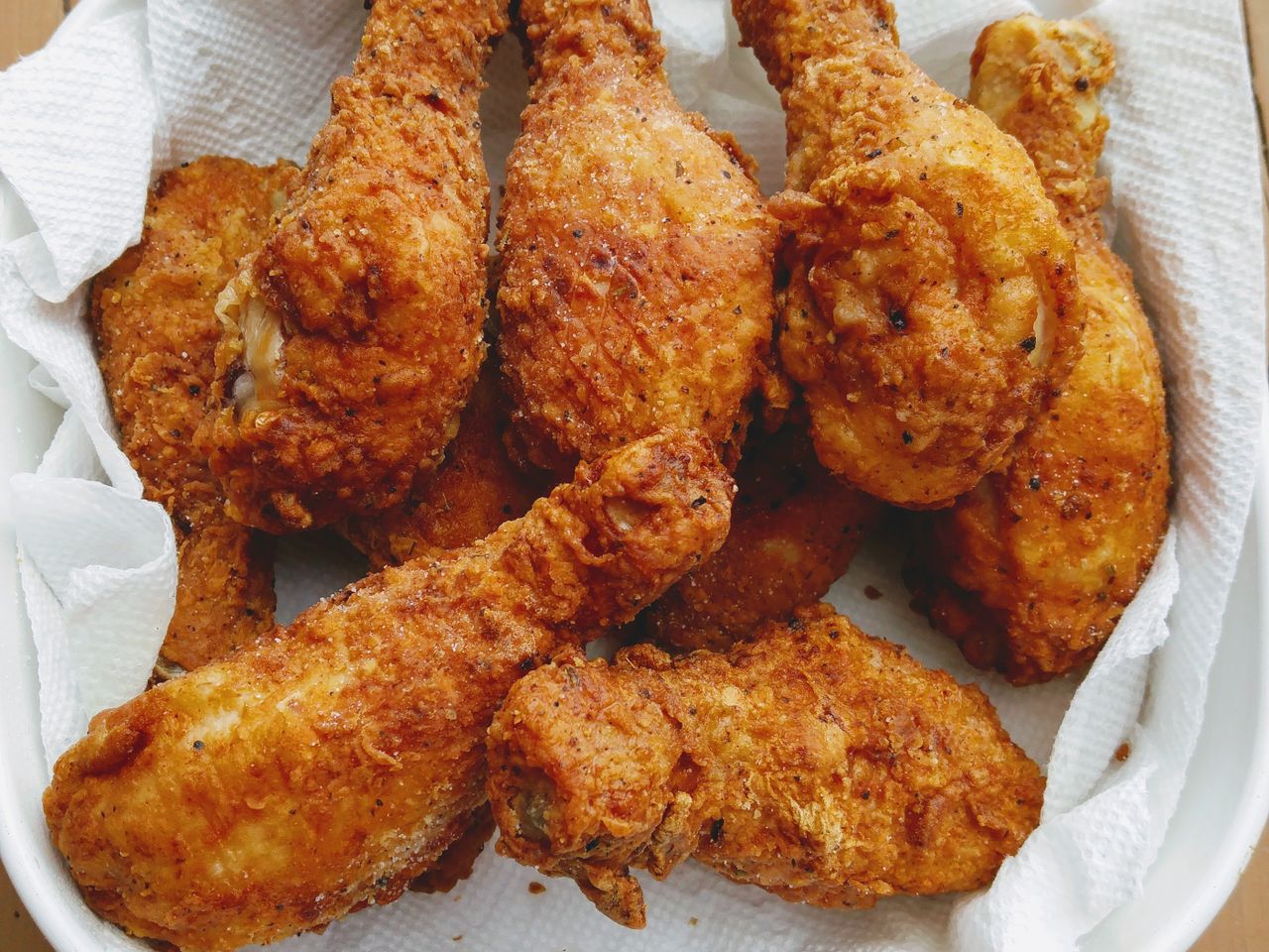 closeup of crispy looking chicken drumsticks in a paper towel-lined dish (Fried Chicken with Creamy Gravy)