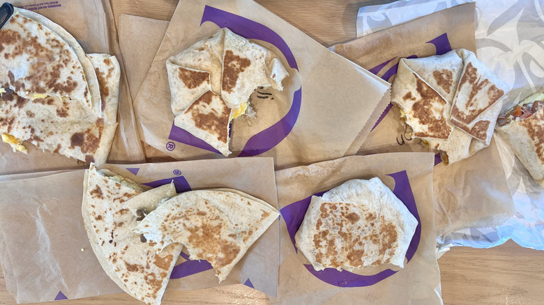 Top view of different Taco Bell breakfast items with bites taken out