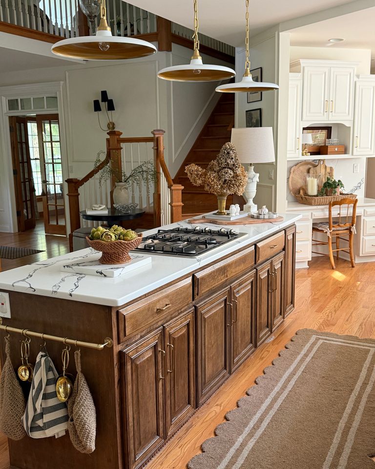 Kitchen with wood cabinets center island gas stove and pendant lights above