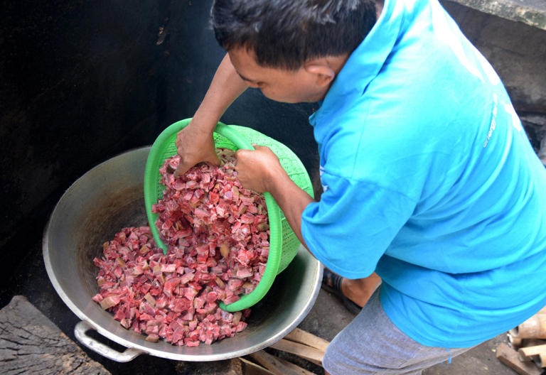 A man prepares chopped up dog meat for a traditional meal at a restaurant in Denpasar, Bali, in 2014. Bali enacted a ban on the dog meat trade in 2023. Photo: AFP
