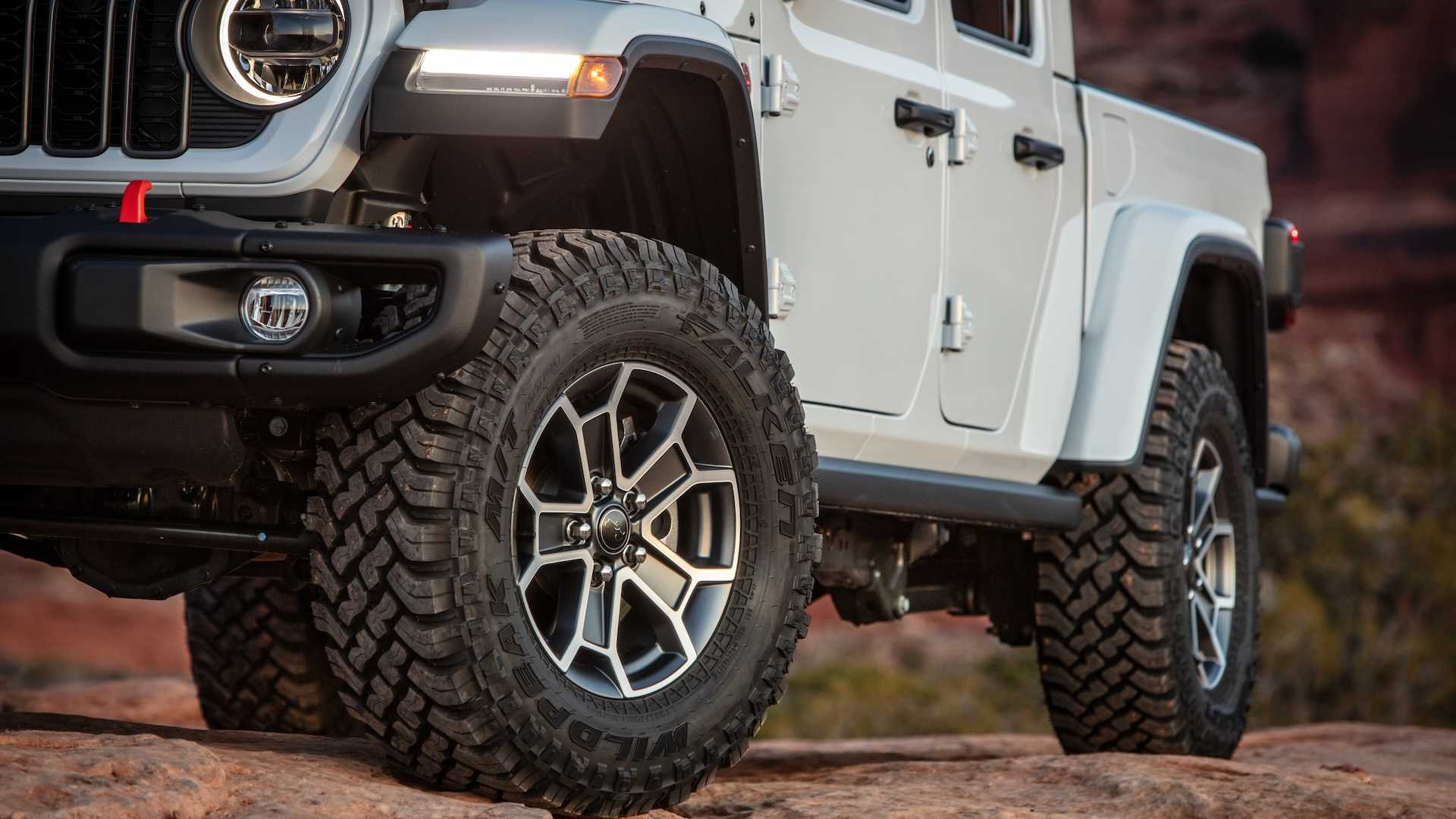 Closeup of the off-road tires beneath a 4WD Jeep pickup truck.