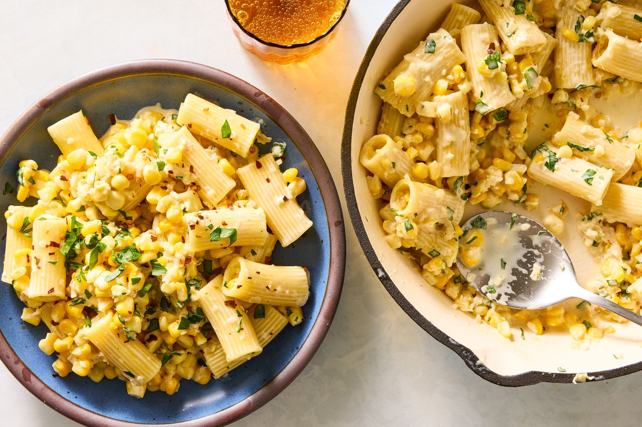 Pasta dish with corn and herbs served in a bowl and in a cooking pan