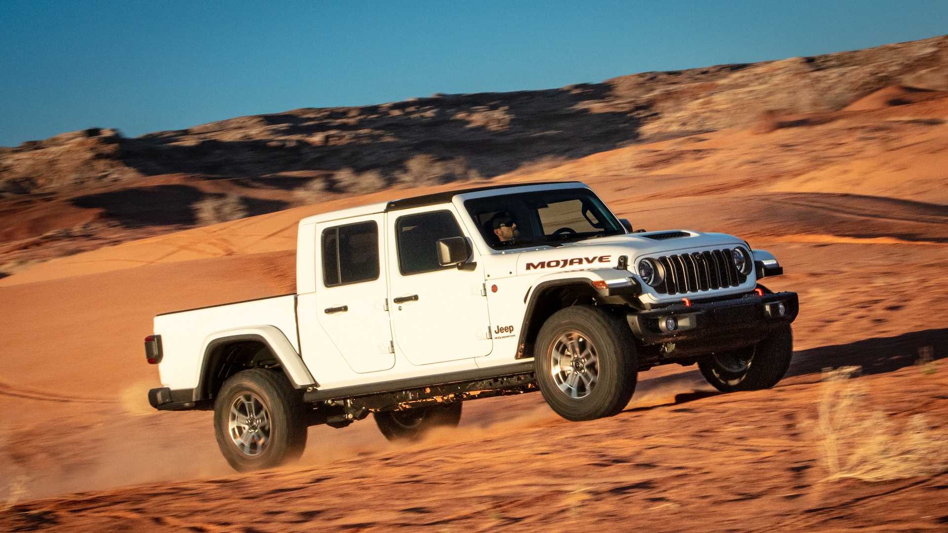 White Jeep Gladiator midsize pickup truck parked in the desert.