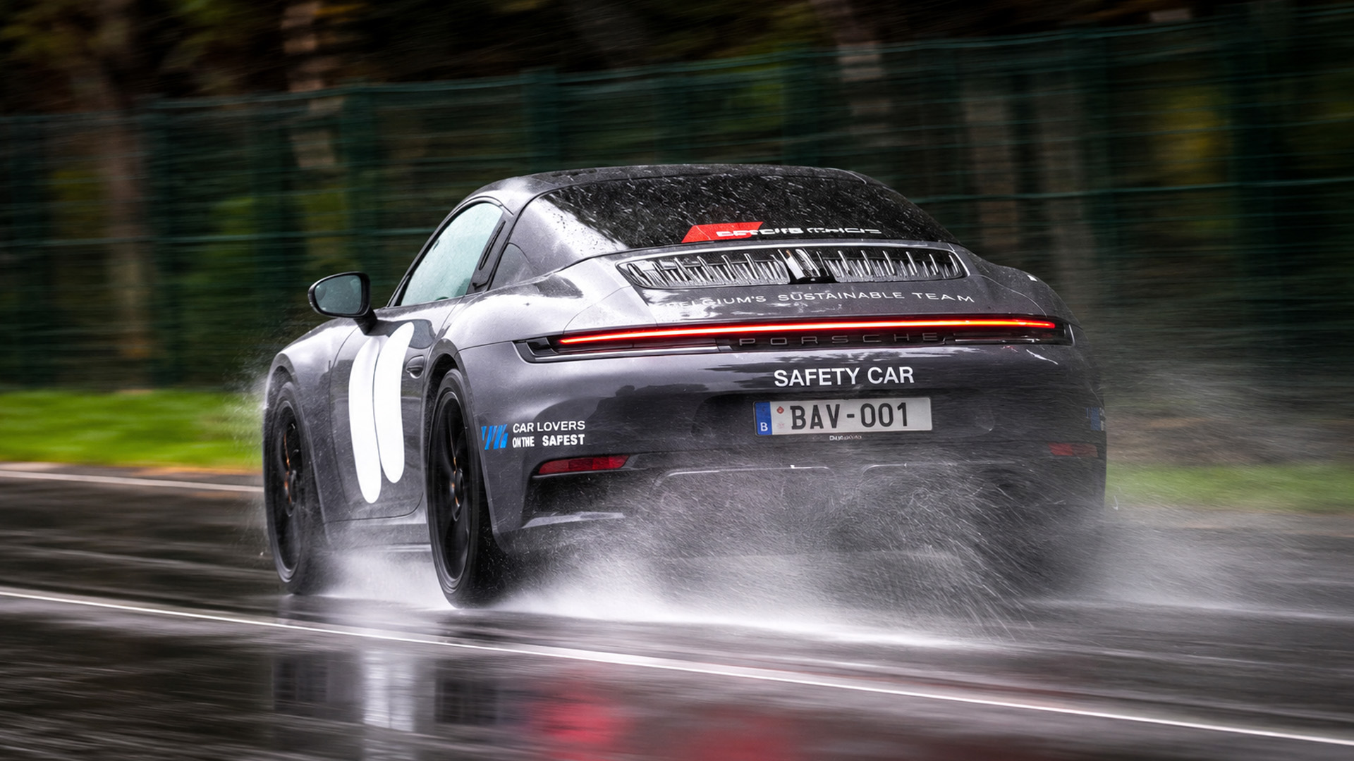 Porsche 911 safety car slides through heavy rain