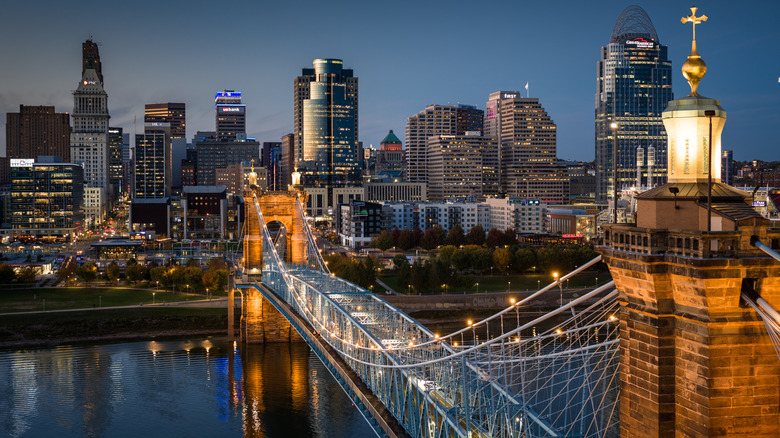 The John A. Roebling Suspension Bridge and the Cincinnati skyline lit up at night.