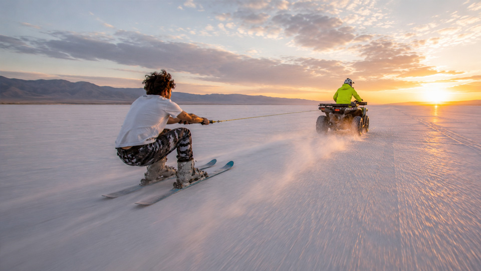 Snowboards glide across salt flats at high speed