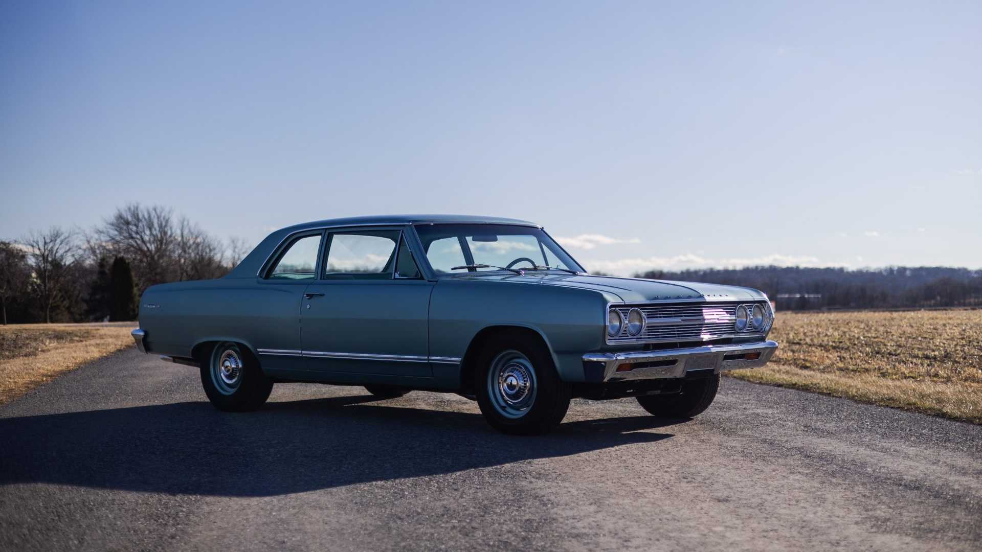 The front of a turquoise classic Chevrolet sedan parked outdoors