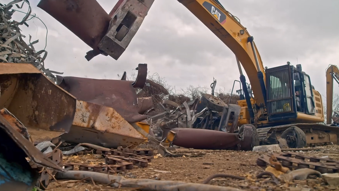 Powerful caterpillar excavator crushing massive steel structures