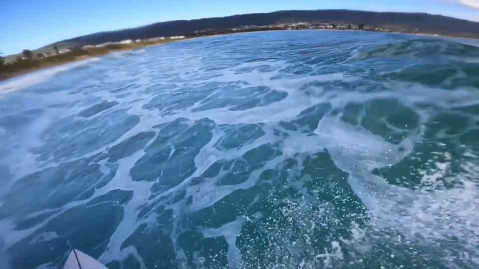 A surfer stays low-key at a localized point break and misses a barrel