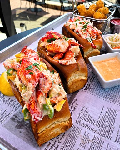 The Connecticut (Warm Buttered), Maine (Cold Lobster Salad, Lightly Dressed), and Tropical (Cold Lobster Salad with Mango-Avocado Salad, Cilantro, Scallions, Lime) lobster rolls at Saybrook Point Resort & Marina.