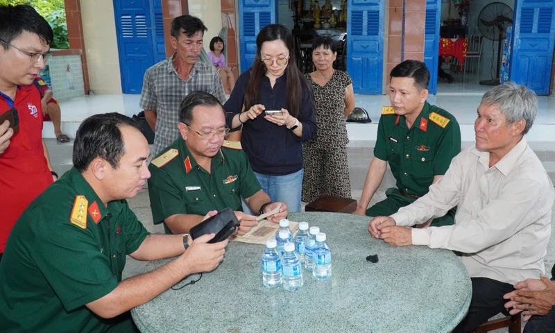 Báo điện tử Tiền Phong Thiếu tướng Nguyễn Thành Trung - Chính ủy Bộ Tư lệnh TPHCM (hàng ngồi, thứ hai từ trái qua) đang xác minh thông tin nhân thân liệt sĩ Huỳnh Văn Quên. Ảnh: Nguyên Phú 1