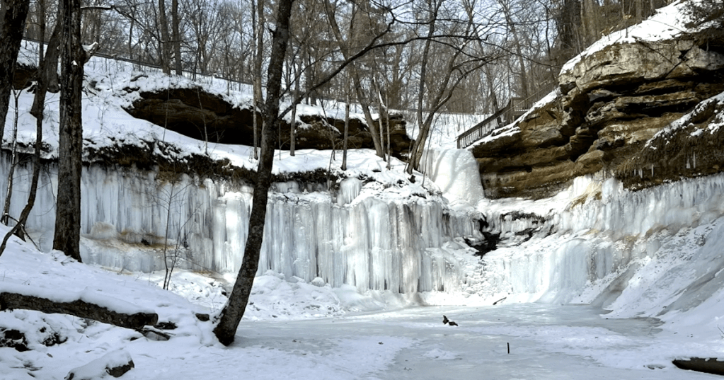 A stunning canyon amphitheater filled with frozen ice walls and snow at Devil's Punchbowl, Wisconsin.
