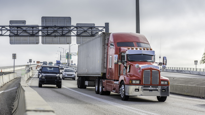 Semi truck traveling the left lane with traffic congestion behind it