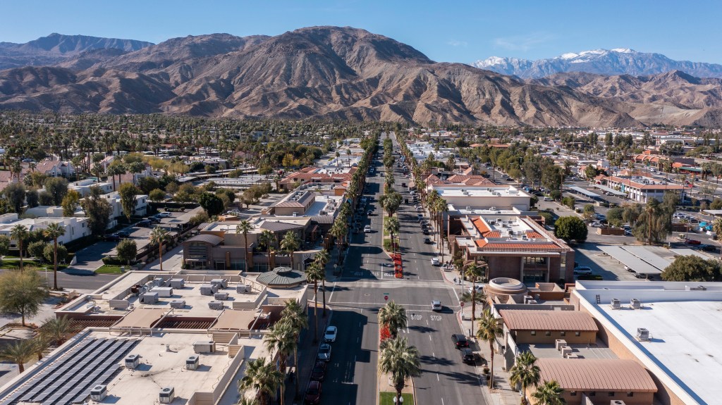Daytime aerial view of the urban downtown area and mountains of Palm Desert, California, USA.