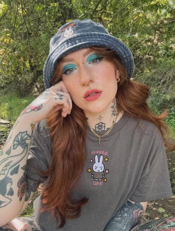 Person outdoors wearing a bucket hat with embroidery and a matching t-shirt that reads