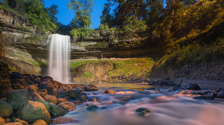 Minnehaha Falls cascading over mossy rocks on sunny day