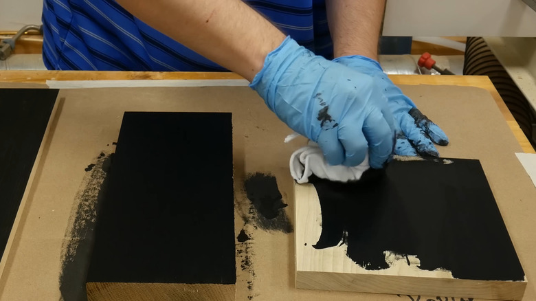 Person finishing pieces of wood with Indian ink