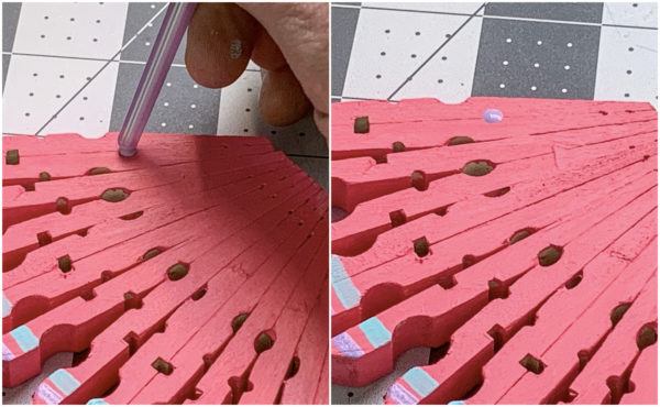 Using the end of a paint brush to put dots on the wing