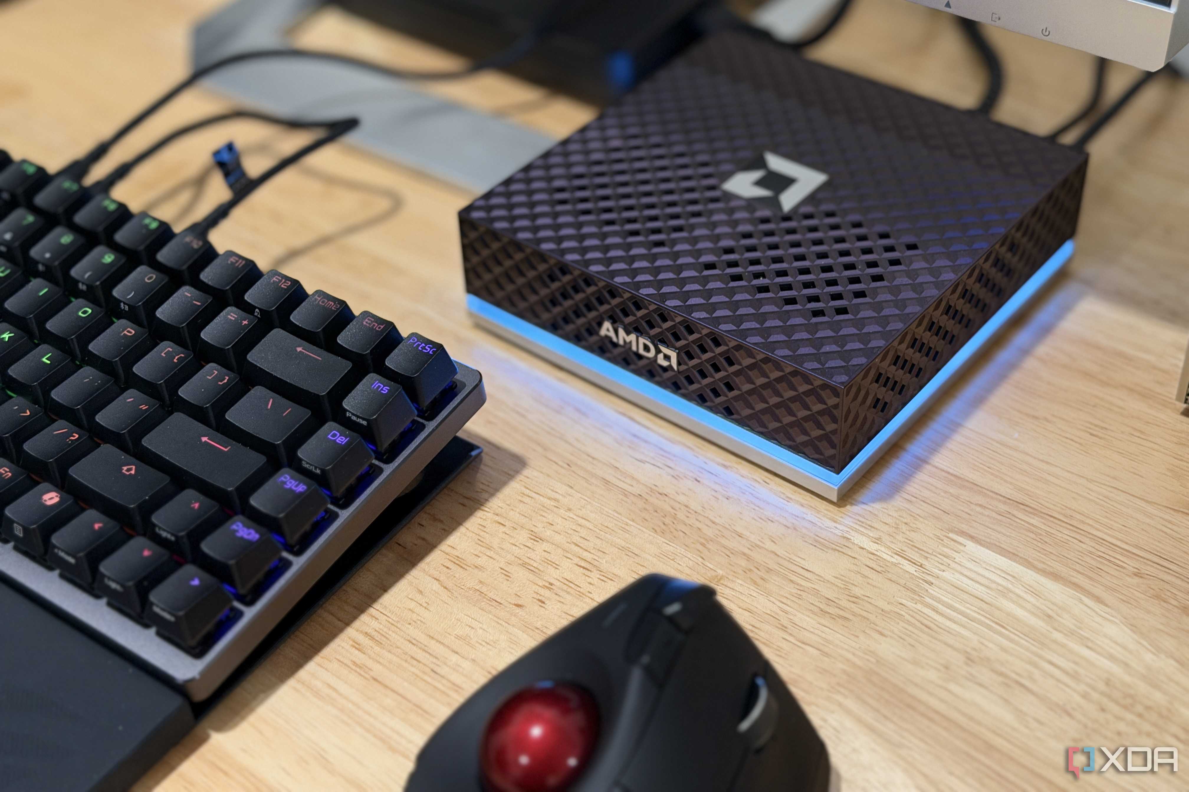 amd ryzen ai halo on a desk next to keyboard and trackball