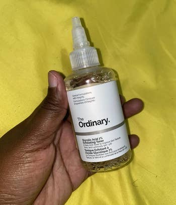 A hand holds a bottle of The Ordinary's Glycolic Acid 7% Toning Solution