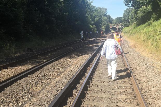 Passengers evacuate train on foot after fire blocks railway line